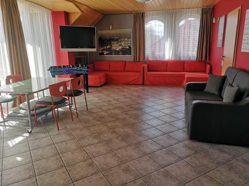 a living room with a red couch and a table at Szigeti Apartmanház in Pécs