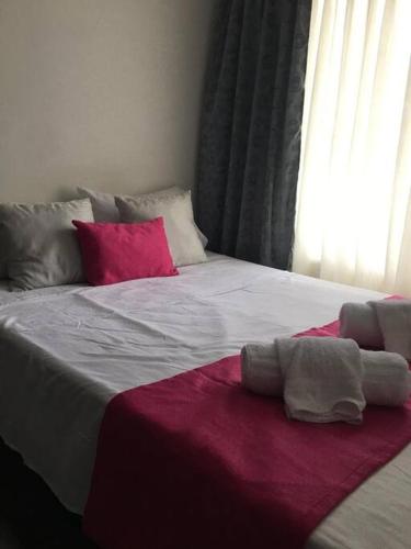 a bedroom with a large bed with a red blanket at ALOJAMIENO CERCA A UKUMARI, CONSOTA, EXPOFUTURO in Pereira