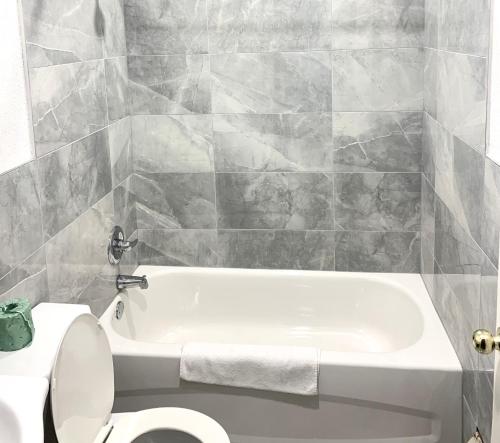 a bathroom with a white tub and a toilet at Bestway Motel in Windsor