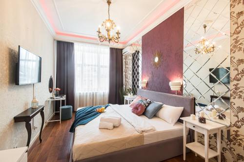 a bedroom with a large bed with a chandelier at GMApartments Red Square in Moscow