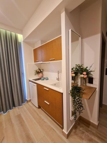 a small kitchen with a sink and a mirror at Alkion Boutique Living in Nea Vrasna