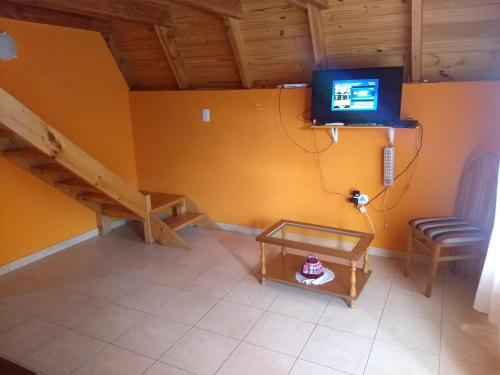 a living room with a tv on the wall at Cabaña El Cóndor in Epuyén