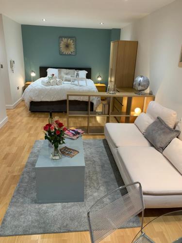 a living room with a bed and a white couch at Modern, City Centre, Studio Apartment with FREE WIFI, GYM ACCESS, NETFLIX - West One in Sheffield