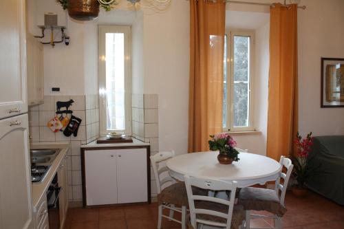 cocina con mesa, mesa blanca y sillas en Agri Domus, en Guidonia