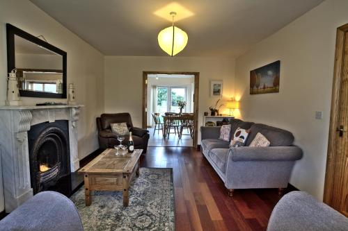 a living room with a couch and a fireplace at Village Lodge - Carlingford in Carlingford