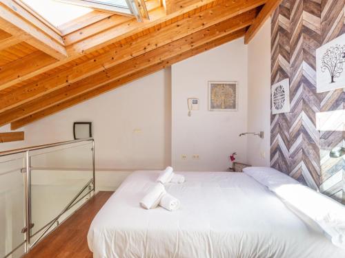 1 dormitorio con cama blanca y techo de madera en LU&CIA DUPLEX City Center, en Málaga