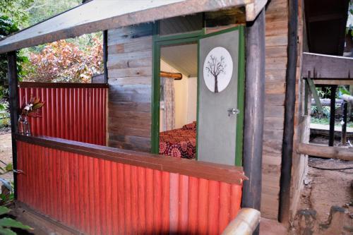a small house with a tree picture on the door at Hazyview Adventure Backpackers in Hazyview