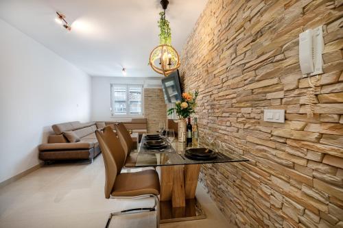 - une salle à manger et un salon avec un mur en briques dans l'établissement Luxury and modern apartment on the main beach, à Split