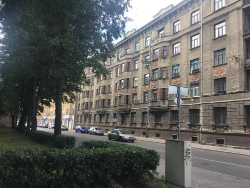ein großes Gebäude, vor dem Autos parken in der Unterkunft Cosy Central Riga Apartment in Riga