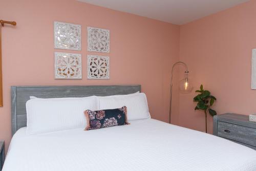 a bedroom with a white bed and pink walls at The Inn on Pamlico Sound in Buxton