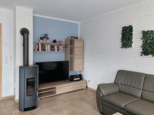 a living room with a fireplace and a couch and a tv at Ferienhaus Meier in Wesenberg