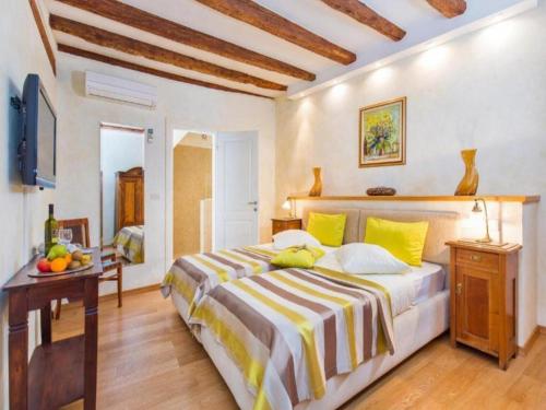 a bedroom with a large bed with yellow pillows at Heritage Hotel Villa Valdibora in Rovinj