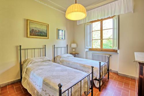 Dos camas en una habitación con ventana. en Casale Ambra by PosarelliVillas, en Ambra