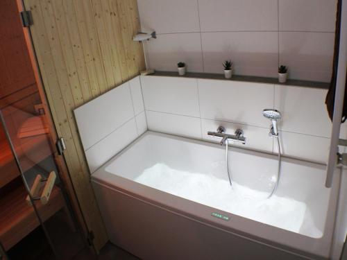 a bath tub with a faucet in a bathroom at Sielhuus 10 in Fedderwardersiel