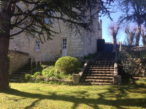 an old stone building with stairs in front of a yard at Château de Bouniagues in Bouniagues