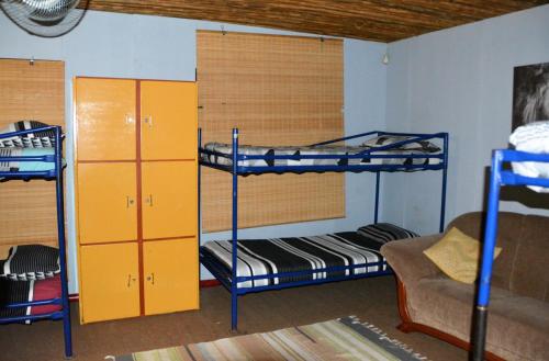 a room with three bunk beds and a couch at Hazyview Adventure Backpackers in Hazyview