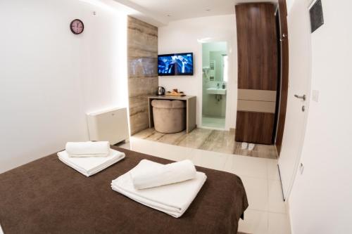 a bedroom with a bed with two towels on it at Princ Apartment in Niš