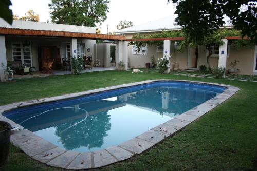 a swimming pool in the yard of a house at Daisy Tree Cottage in Oudtshoorn