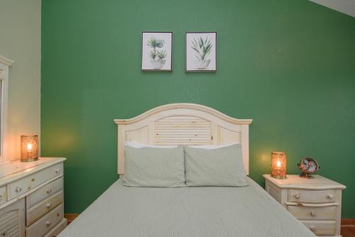 a green bedroom with a bed and two pictures on the wall at The Inn on Pamlico Sound in Buxton