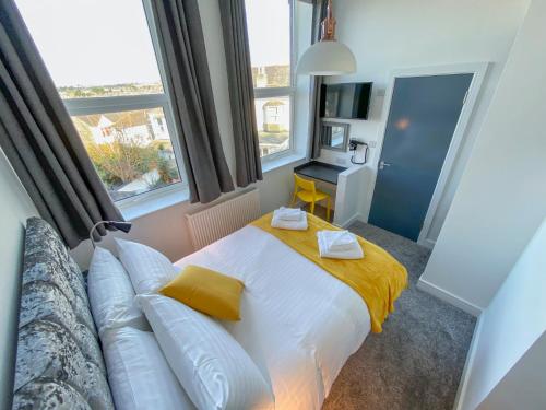 ein Schlafzimmer mit einem Bett, einem Sofa und Fenstern in der Unterkunft Victoria by Pureserviced in Plymouth