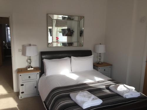 1 dormitorio con 1 cama grande con 2 lámparas y espejo en Mess Deck by Pureserviced, en Plymouth