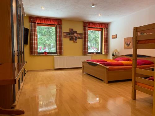 a bedroom with two beds and two windows at Pension Pöhlbergblick Annaberg in Annaberg-Buchholz