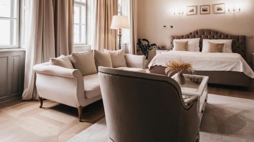 - une chambre avec un lit, un canapé et une chaise dans l'établissement Room42 - Suites & Apartments, à Esztergom