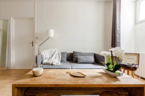 un salon avec un canapé et une table en bois dans l'établissement Hyper centre Toulouse : T3 à Jeanne d Arc, à Toulouse