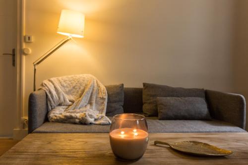 une bougie sur une table devant un canapé dans l'établissement Hyper centre Toulouse : T3 à Jeanne d Arc, à Toulouse