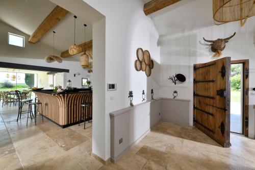 a kitchen and dining room with white walls and a wooden door at Mas du Couvin, maison d'hôtes en Camargue in Saintes-Maries-de-la-Mer