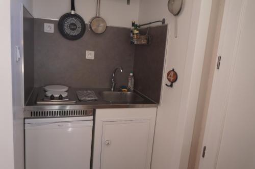 uma pequena cozinha com um lavatório e um fogão em Chambre d'Hôtes - l'Ephémère em Limoges