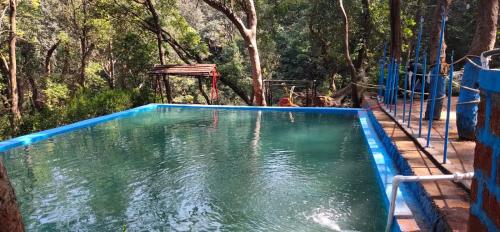 a pool of water with trees in the background at Bungalow resort panorama matheran in Matheran