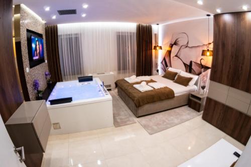 a bedroom with a bed and a bath tub at Princ Apartment in Niš