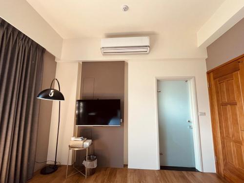 una sala de estar con ventilador de techo y una habitación en 禾樂號Hello House, en Luodong
