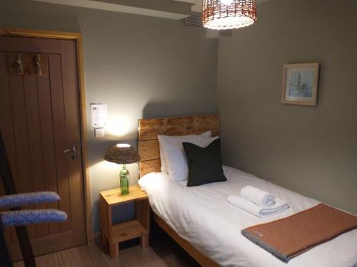 a bedroom with a bed with towels on it at South Downs Eco Lodge & Camping in East Meon