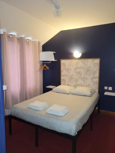 Een bed of bedden in een kamer bij contact hôtel Le Temps Perdu