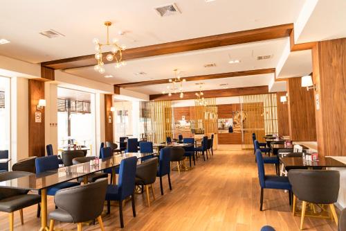 une salle à manger avec des tables et des chaises bleues dans l'établissement DM Hoteles Tacna, à Tacna