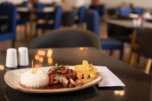 a plate of food with rice and shrimp and waffles at DM Hoteles Tacna in Tacna