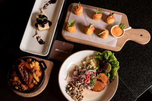 a table with two trays of food and a plate of food at DM Hoteles Tacna in Tacna