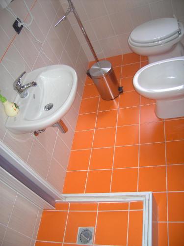 an orange tiled bathroom with a sink and a toilet at B&B del centro storico *** in Rosolini