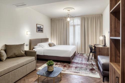 a hotel room with a bed and a couch at Porta Altinia Suites in Treviso