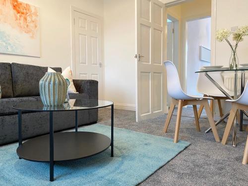 a living room with a couch and a table at Gladsmuir House in Glasgow