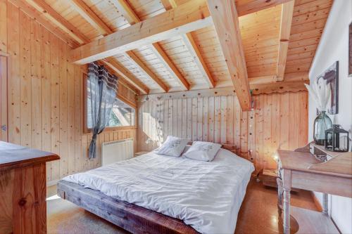 ein Schlafzimmer mit einem Bett in einer Holzhütte in der Unterkunft Le Tournavel in Praz-sur-Arly