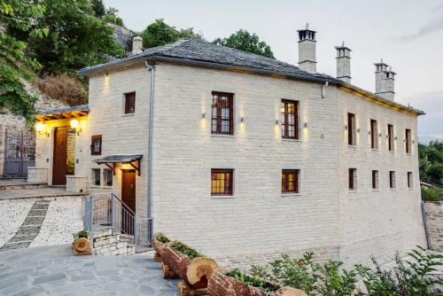 a large white brick building with two chimneys at Archontiko Evridikis in Vitsa