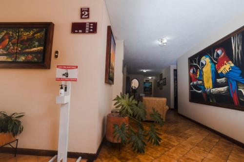 a hallway with a painting of birds on the wall at HOTEL ACHALAY in Popayan