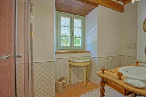 baño con ducha, lavabo y ventana en Casale San Martino by PosarelliVillas, en Cortona