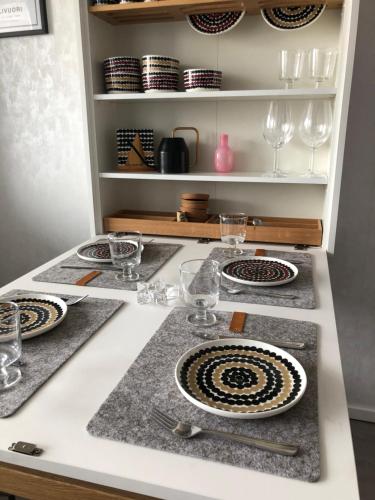 a kitchen with plates and glasses on a counter at Ellivuori Lake View in Sastamala