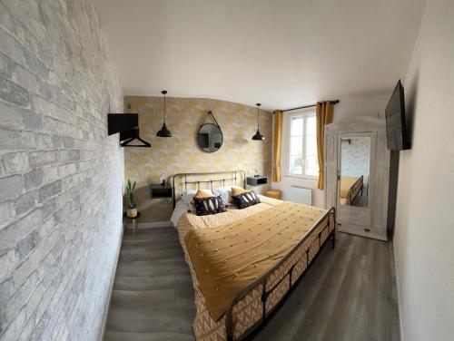 ein Schlafzimmer mit einem Bett und einer Ziegelwand in der Unterkunft Le velocipede in Aumale