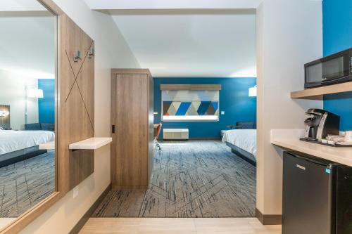 a hotel room with two beds and a kitchen at Holiday Inn Express & Suites Charlottesville by IHG in Charlottesville