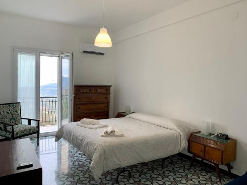 a bedroom with a bed and a dresser and a window at Casa Magnolia in Castelbuono